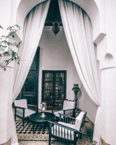 white exterior with a three black chairs and a table
